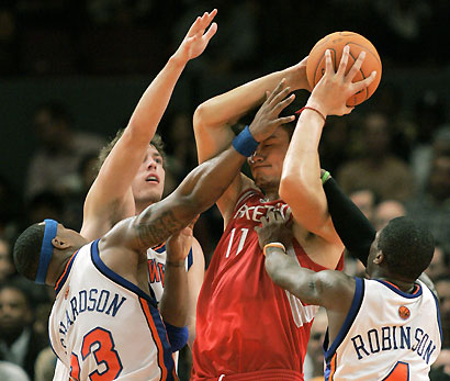 New York Knicks forwards Quentin Richardson (bottom L) and David Lee (2nd L) and guard Nate Robinson (R) surround Houston Rockets center Yao Ming after he controlled a rebound in the fourth period of their NBA basketball game in New York November 20, 2006.