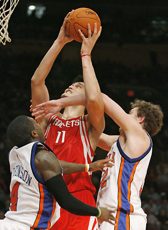 Houston Rockets guard Tracy McGrady (R) keeps the ball away from New York Knicks forward Quentin Richardson in the fourth quarter of their NBA basketball game in New York November 20, 2006. 