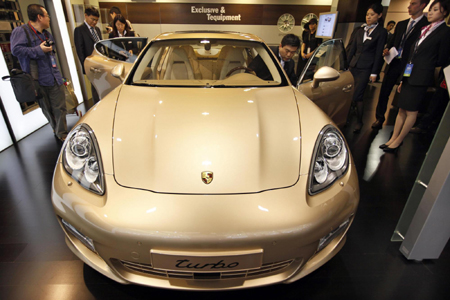 Visitors check out a model of Porsche's new Panamera S
