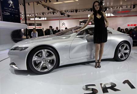 Model poses next to a Peugeot SR1 car