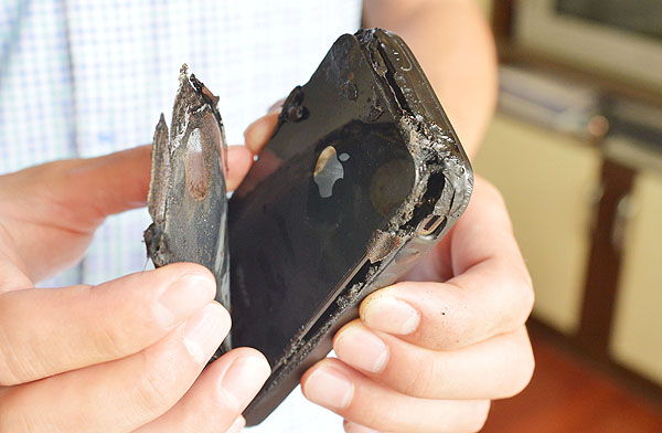 Wang Kai shows the debris of his iPhone 4, Apple's 4th-generation smartphone, after it ignited in Chongqing, on July 9, 2013. He said he was sound asleep when the phone spontaneously combusted and burnt his mat. Apple's after-sales service has been notified, saying they are investigating whether user error is to blame. Safety fears after iPhone 4 explodes
