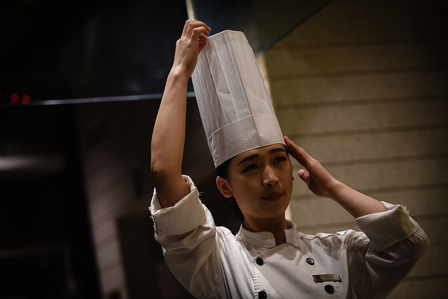 Young female chef performs for five-star hotel guests