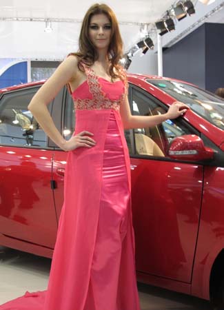 Model poses next to a car by Dongfeng Motor