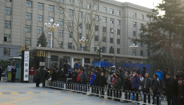 People wait in line to take photos in front of the defunct Ministry of Railways before the sign is removed, in Beijing, on Thursday. Keepsake photos of Railway Ministry