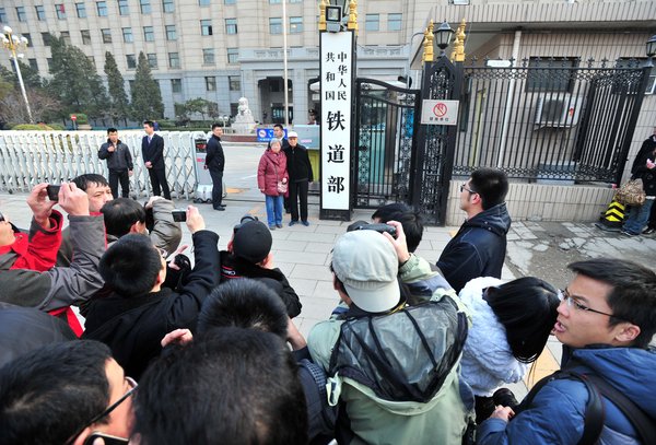 Residents and media take photos in front of the defunct Ministry of Railways before the sign is removed, in Beijing, March 14, 2013. Keepsake photos of Railway Ministry