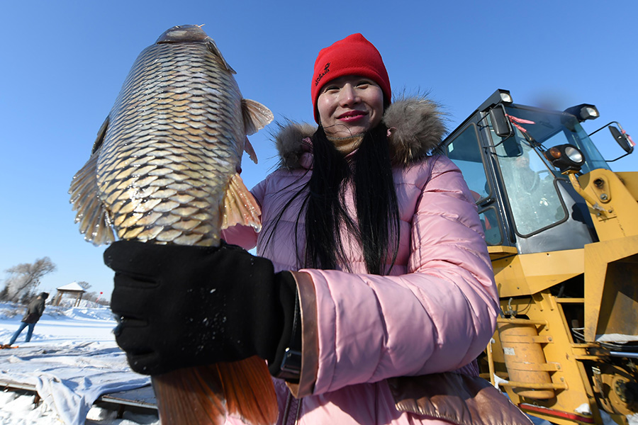 Winter fishing in ice-covered Changling Lake in Harbin