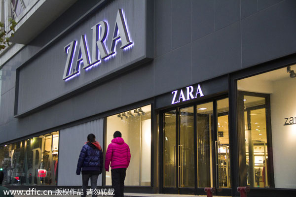 ... walk past a store of Zara in Shanghai, China, Dec 26, 2013. PhotoIC