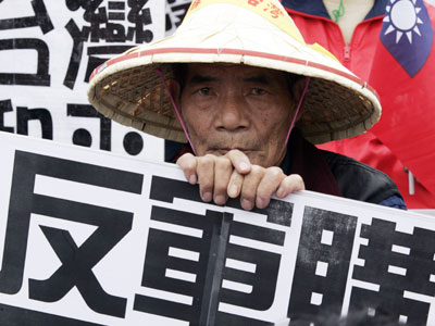 A protestor holds a sign opposing arms purchases from the U.S. sought by Taiwan President Chen Shui-bian in a rally organized by the main opposition parties in Taipei, March 19, 2006.