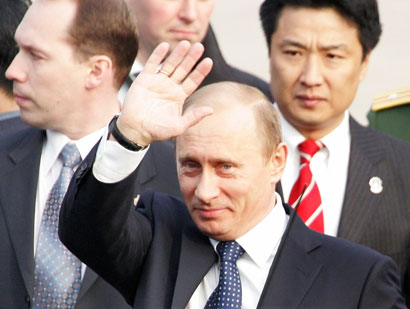 Russian President Vladimir Putin waves after arriving at Beijing International Airport March 21, 2006. Russia and China aim to more than double bilateral trade by 2010, officials from both countries said, during a trip to China by President Vladimir Putin that will focus on deepening energy cooperation. Putin is visiting China March 21-22.