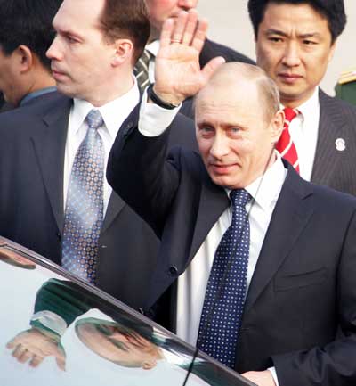 Russian President Vladimir Putin waves after arriving at Beijing International Airport March 21, 2006. Russia and China aim to more than double bilateral trade by 2010, officials from both countries said, during a trip to China by President Vladimir Putin that will focus on deepening energy cooperation. Putin is visiting China March 21-22. 
