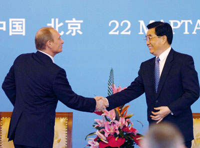 Russian President Putin (L) shakes hands with Chinese President Hu Jintao after his speech at the Sino-Russian Industrial and Commercial Forum at Diaoyutai State Guest House in Beijing March 22, 2006. 