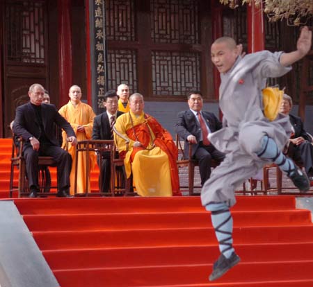 Russian President Vladimir Putin watches monks perform martial arts during a visit to the Shaolin Temple in Central China's Henan Province March 22, 2006. Shaolin Temple is widely believed as the origin of martial arts. [Xinhua]