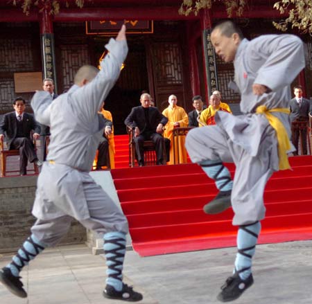 Russian President Vladimir Putin watches monks perform martial arts during a visit to the Shaolin Temple in Central China's Henan Province March 22, 2006. Shaolin Temple is widely believed as the origin of martial arts. [Xinhua]