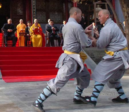 Russian President Vladimir Putin watches monks perform martial arts during a visit to the Shaolin Temple in Central China's Henan Province March 22, 2006. Shaolin Temple is widely believed as the origin of martial arts. [Xinhua]