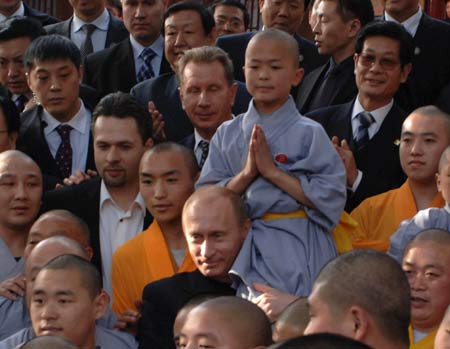 Russian President Vladimir Putin perches a monk on his head during a visit to the Shaolin Temple in Central China's Henan Province March 22, 2006. Shaolin Temple is widely believed as the origin of martial arts. [Reuters] 