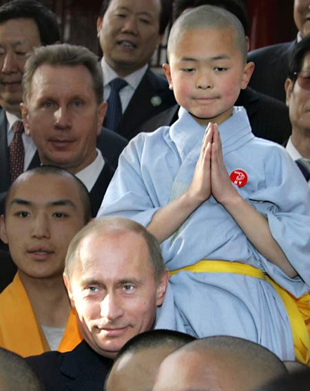 Russian President Vladimir Putin perches a monk on his head during a visit to the Shaolin Temple in Central China's Henan Province March 22, 2006. Shaolin Temple is widely believed as the origin of martial arts. [Reuters] 