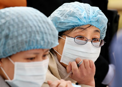 Health workers help residents to vaccinate their birds against bird flu, as arranged by the local authorities, in a park in Bejing March 31, 2006. The H5N1 bird flu virus has infected 16 people in China, of whom 11 have died. The virus is now endemic in poultry across much of the world despite widespread culling of birds and mass vaccinations of fowl.