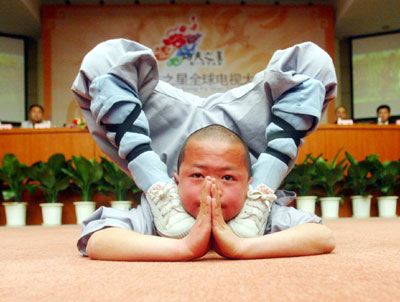 Shi Xiaoguang, an 8-year-old monk who sat on Russian President Vladimir Putin's shoulder when Putin visited Shaolin Temple last Wednesday, performs at a news conference for the launch of 'The stars of Chinese Kongfu Contest' in Beijing, China March 30, 2006. 108 contestants well-versed in the art of kungfu will be then chosen to act in the teleplay 'Shaolin Temple'.