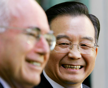 Chinese Premier Wen Jiabao (R) laughs as he listens to Australian Prime Minister John Howard during a media conference in Canberra's Parliament House April 3, 2006. Australia and China signed a nuclear safeguards deal on Monday to allow Beijing to import Australian uranium for power generation, but an Australian minister said exports were unlikely to start for some years. 