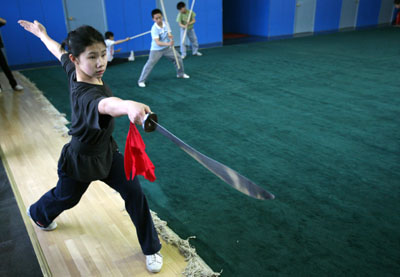 A student practices Wushu, a traditional martial art, at the Shi Cha Hai boarding sports school in Beijing April 5, 2006. The school is famous for training students for competitive sports from national tournaments to the Olympic games. [Reuters]