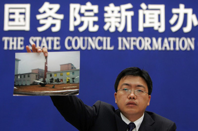 Zhang Xu, a senior official at the National Traditional Chinese Medicine Thrombus Treatment Center in Shenyang, holds up a picture he says shows that the claims by the outlawed Falun Gong group of organ harvesting at the hospital cannot be true, during a news conference in Beijing April 12, 2006. [Reuters]