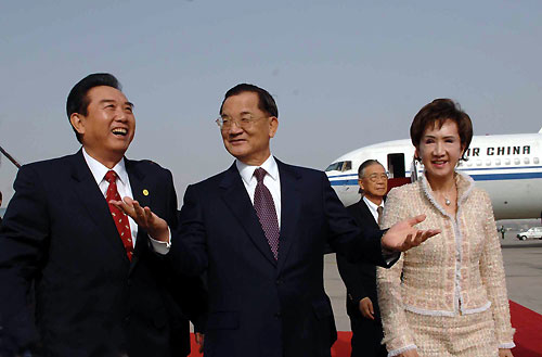 Lien Chan(C), former chairman of Taiwan's main opposition Kuomingtang party talks with China's Taiwan Affairs Office Director Chen Yunlin(L) as he arrives at Beijing International Airport with his wife Lien Fang Yu. Lien arrived in Chinese mainland calling for stronger trade ties with the mainland as a bridge to cross-strait peace and prosperity. [Xinhua]