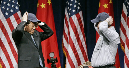 President Hu Jintao (L) puts on a Boeing baseball hat presented to him by employee Paul Demier during his visit to the plane manufacturing plant in Everett, Washington April 19, 2006. 