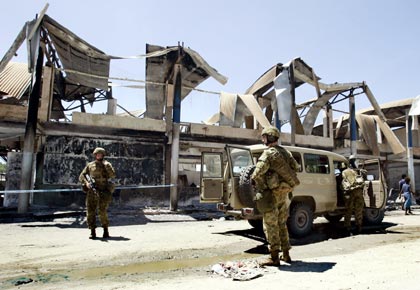 Australian soldiers stand guard on a street in the Chinatown district of the Solomon Islands' capital Honiara April 24, 2006. The Solomon Islands parliament was sworn in under heavy security on Monday amid fears the first sitting since last week's devastating riots in the capital could trigger further violence.