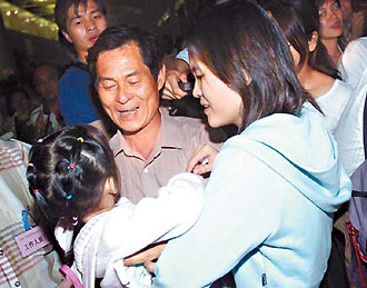 Hu Meili and her daughter are welcomed by her father, Hu Yuebin, at Guangzhou Baiyun International Airport upon their arrival in South China's Guangdong Province. The first group of Chinese evacuated from the riot-torn Solomon Islands flew back to China yesterday on a chartered flight. (Xinhua)