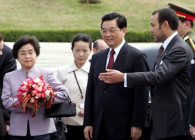 President Hu Jintao (C) and his wife Liu Yongqing (L) are welcomed by Moroccan King Mohammed in Rabat April 24, 2006. Hu kicked off a three-nation tour of Africa in Morocco on Monday, boosting already booming ties to a continent rich in the energy and minerals his country needs to feed a fast-growing economy.