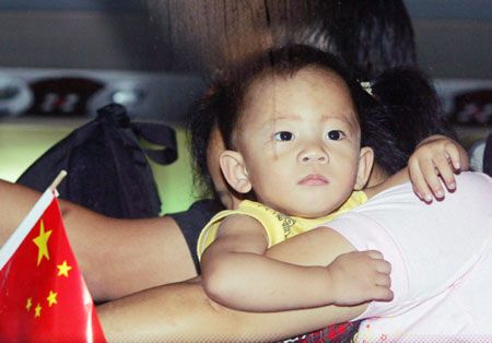 A young Solomon Islander of Hong Kong descent is carried onto a bus after arriving in Guangzhou, southern China's Guangdong province, April 25, 2006. More than 300 Chinese, including some from Hong Kong, board a chartered flight provided by Beijing that evacuated them from the troubled Solomon Islands after they lost all their possessions in the recent riots in Honiara. More ethnic Chinese fled the country amid rising tensions before parliament opens for the first time since post-election rioting.