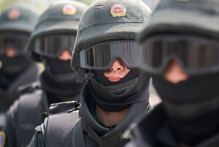 Masked members of a Chinese police SWAT team attend a ceremony to launch their Olympic security training programme in Beijing April 27, 2006. Beijing's 40,000 police officers and any more recruited before the Olympics, will take part in the training with the majority having language training to deal with the more than two million visitors expected before and during the games.