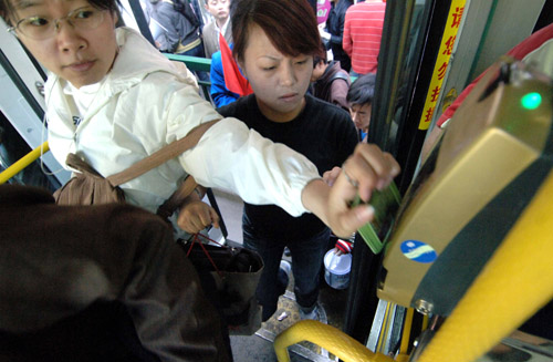 a bus rider uses his smart card to高清图片