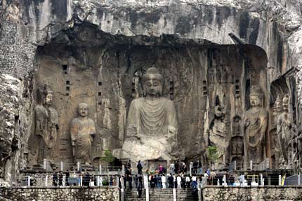 Tourists visit Longmen Grottoes in the city of Luoyang in China's central province of Henan May 12, 2006. "Longmen Grottoes" is one of China's UNESCO World Heritage sites in Henan Province. Longmen has more than 2,300 grottoes with 110,000 Buddhist images, over 80 dagobas and 2,800 inscribed tablets on cliffs with a length of one kilometer along the Yishui River, where Buddhism was first introduced to China during the Eastern Han Dynasty (25 - 220), according to Xinhua News. [Reuters]