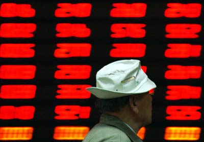 A stock investor looks at an electronic board showing stock information at a stock trading company in Shanghai, May 12, 2006. The benchmark Shanghai composite index closed at 1602 points, its highest level in almost two years. [Newsphoto]