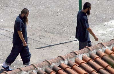 Two of five Chinese suspects, released from the US-run Guantanamo prison, walk in an Albanian refugees center in Tirana May 12, 2006. The Chinese government has demanded immediate return of five Chinese nationals who are by no means refugees but terrorist suspects, said Foreign Ministry spokesman Liu Jianchao. The five from Northwest China's Xinjiang Uygur Autonomous Region are suspected of being members of the East Turkistan Islamic Movement. They were held in Guantanamo for several years after being picked up during the US invasion of Afghanistan following the September 11, 2001, terrorist attacks. [Reuters]