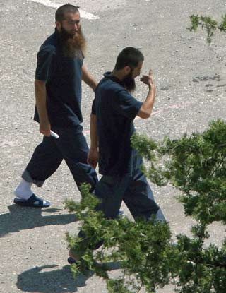 Two of five Chinese suspects, released from the US-run Guantanamo prison, walk in an Albanian refugees center in Tirana May 12, 2006. The Chinese government has demanded immediate return of five Chinese nationals who are by no means refugees but terrorist suspects, said Foreign Ministry spokesman Liu Jianchao. The five from Northwest China's Xinjiang Uygur Autonomous Region are suspected of being members of the East Turkistan Islamic Movement. They were held in Guantanamo for several years after being picked up during the US invasion of Afghanistan following the September 11, 2001, terrorist attacks. [Reuters]