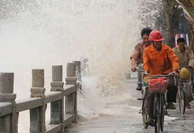 Several cyclists ride through a bridge as strong waves rage in Zhuhai, south China's Guangdong province May 16, 2006. Typhoon Chanchu is barrelling towards southern China after claiming at least 41 lives in the Philippines and becoming the strongest storm on record to enter the South China sea in May. [Xinhua]