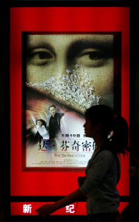 A woman walks past a poster of the movie "The Da Vinci Code" in China's capital Beijing May 18, 2006. 