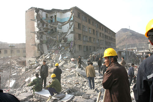 Rescuers dig through debris yesterday after an explosion severely damaged a five-storey dormitory housing medical staff at Xuangang Coal and Electricity Co. Ltd. in Yuanping, North China's Shanxi Province. [Newsphoto]