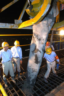 Workers pour the last batch of concrete into a section of the Three Gorges Dam on Friday as they try to complete construction of the dam structure 10 months ahead of schedule at 2 pm on Saturday. (Xinhua)