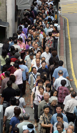 Residents collect prospectuses for the initial public offering of Bank of China in Hong Kong, May 18, 2006. 