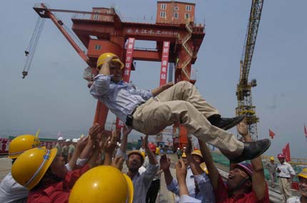 Builders of the Three Gorges Project, hold red flags in celebrating the completion of concrete placement of the mammoth Three Gorges dam, Saturday afternoon May 20, 2006. Construction crews finished the main dam structure of the world's largest hydroelectric project on Saturday, Xinhua reported. [Xinhua]