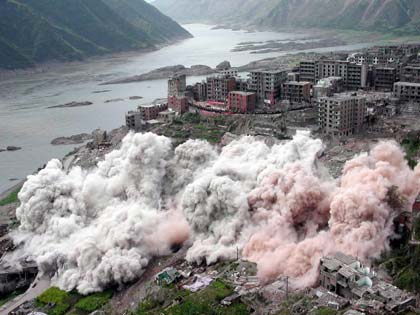 Residential buildings are demolished for the construction of the Three Gorges Project, in this March 24, 2002 file photo. More than 1.13 million people have been relocated to make way for the project, and more than 100 workers reportedly lost their lives in various accidents during construction.Construction crews finished the main dam structure of the world's largest hydroelectric project on Saturday, Xinhua reported. [Xinhua/file]