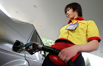 A petrol station worker fills the tank of a car in Beijing May 23, 2006. China will raise retail gasoline and diesel prices by a larger-than-expected 10-11 percent from May 24, the second increase this year, taking the total rise to about 15 percent.