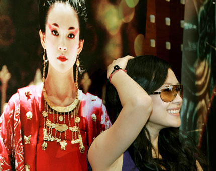 Chinese actress Zhang Ziyi stands near her image on a movie poster during a photocall for Chinese director Feng Xiaogang's film "The Banquet" at the 59th Cannes Film Festival May 23, 2006.