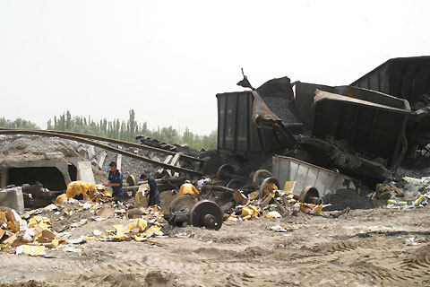Cargo cars lie detrailed Friday after a torrential rain raged Atushi, a town 1500-kilometer west to Urumchi, capital of Northwest China's Xinjiang Uyguir Autonomous Region. No casualty report is available. The rain began on late Thursday in the area with an everage yearly rainfall of 76mm. [newsphoto] 