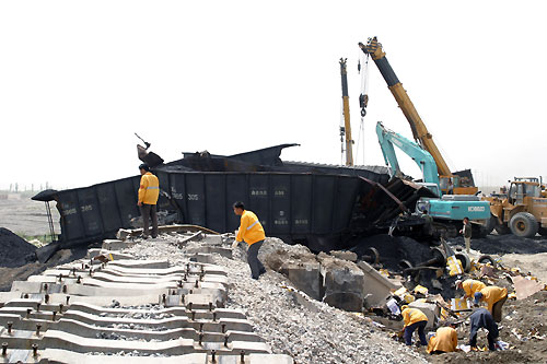 Cargo cars lie detrailed Friday after a torrential rain raged Atushi, a town 1500-kilometer west to Urumchi, capital of Northwest China's Xinjiang Uyguir Autonomous Region. No casualty report is available. The rain began on late Thursday in the area with an everage yearly rainfall of 76mm. [newsphoto] 