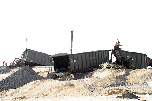 Cargo cars lie detrailed Friday after a torrential rain raged Atushi, a town 1500-kilometer west to Urumchi, capital of Northwest China's Xinjiang Uyguir Autonomous Region. No casualty report is available. The rain began on late Thursday in the area with an everage yearly rainfall of 76mm. [newsphoto] 