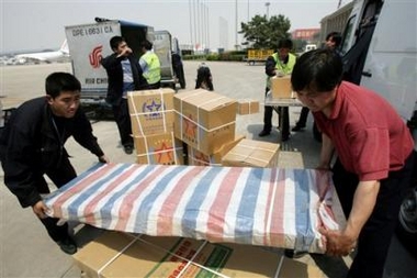 Airport staff prepare to load an Air China plane with the relief materials and equipment for rescue operation as members of the Chinese International Search and Rescue (CISAR) team board the plane departing for Yogyakarta, at the Beijing Capital International airport Monday, May 29, 2006. China has offered two million dollars in aid, together with personnel and materials to Indonesia following a devastating earthquake on the Indonesian main island of Java. [AP]